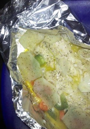 A picture of baked whiting with potatoes and vegetables.