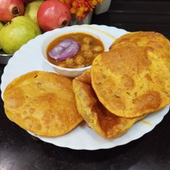 A picture of Punjabi Thali - Chana Masala Curry with Methi Masala Puri.