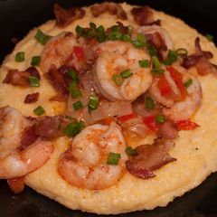 A picture of Shrimp and cheesy grits with bacon.