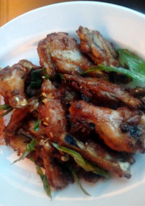 A picture of deep fry chicken wings with pandan leaves.