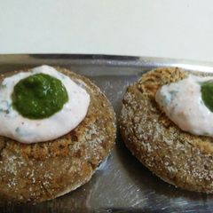 A picture of Black Chana cutlet topped with hung curd and coriander mint chutney.