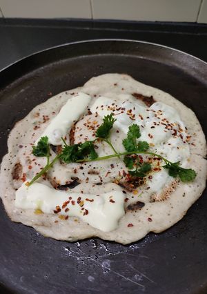 A picture of Owar cheese pizza dosa with tomato onion chutney gravy.