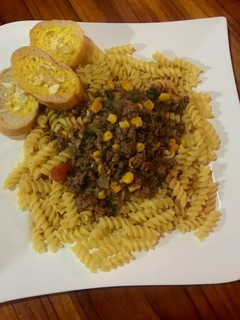 Una foto de Pasta con carne molida, maíz dulce en salsa roja