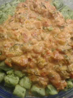 Una foto de Ñoquis de espinaca con salsa de tomates cubeteados, verdeo y crema