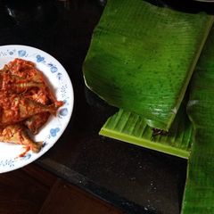 A picture of Steamed fish in banana leaves.