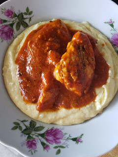 Una foto de Polenta con pechuga en salsa roja