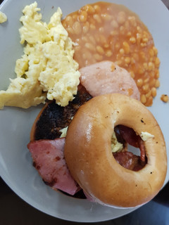 A picture of My Buttered toasted Bagel with Bacon,scrambled Egg + Beans. 💖.