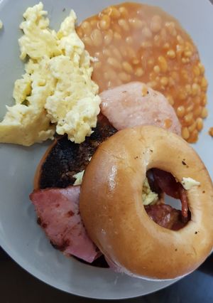 A picture of My Buttered toasted Bagel with Bacon,scrambled Egg + Beans. 💖.