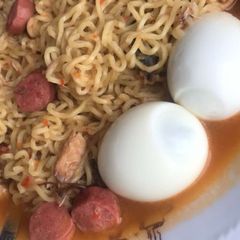 A picture of Noodles with sausage rolls and sardine.