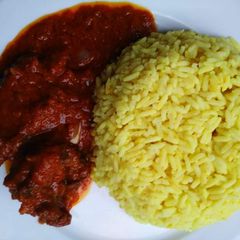 A picture of Curry rice with tomato goat meat sauce.