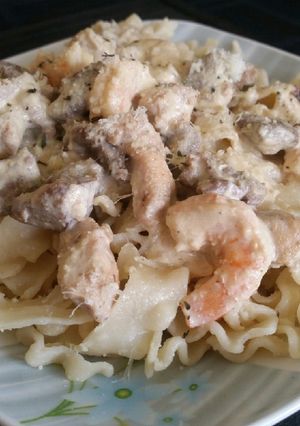 Una foto de Pasta con salsa de camarones, pollo y carne