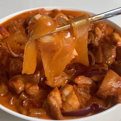 A picture of Korean spicy carbonara chicken with wide glass noodles.