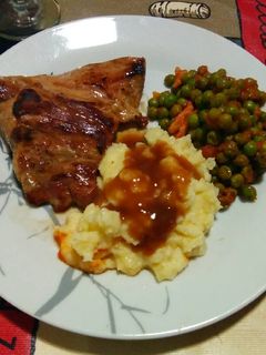 Una foto de Secreto ibérico con guarnición de guisantes y puré de patatas
