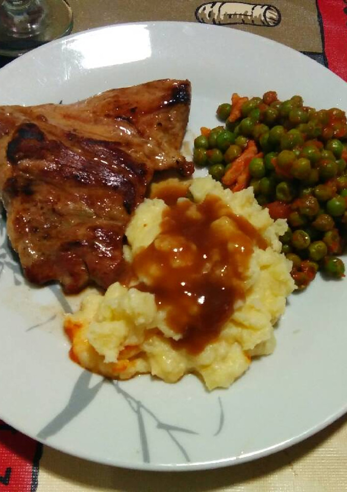 Una foto de Secreto ibérico con guarnición de guisantes y puré de patatas