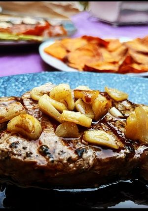 A picture of Smoked Beef Tenderloin with Confit Garlic, Sweet Potato Chips, and Grilled Vegetables.