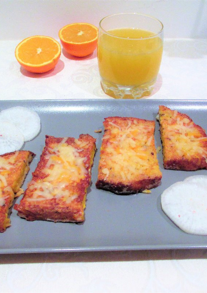 Una foto de Pan rústico empapado en huevo con queso rallado y zumo de cítricos - desayuno