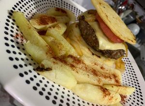 Una foto de Hamburguesa con arepa, cadera de res aromatizada y papa rústica