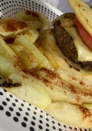 Una foto de Hamburguesa con arepa, cadera de res aromatizada y papa rústica