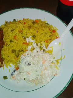 A picture of Fried rice, Cole slaw, fried chicken drum stick.