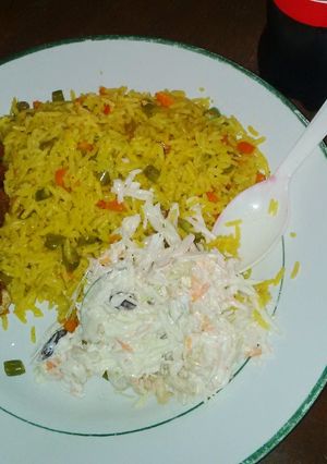 A picture of Fried rice, Cole slaw, fried chicken drum stick.
