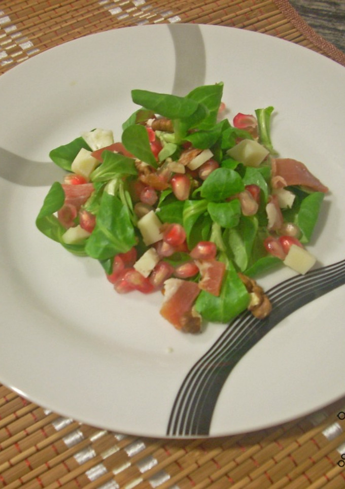 Una foto de Ensalada de canónigos, granada y queso