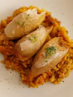 Una foto de Arroz con calamares rellenos de gambas y boloñesa con velo de panceta ibérica