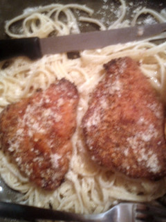 A picture of baked chicken with parmesan and herbs.