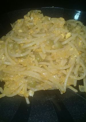 Una foto de Fideos revueltos con colchón de arvejas y cebolla