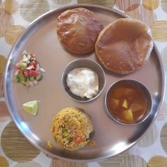 A picture of Puri, batata rassa, Masalebhat, shrikhand & Koshimbir.