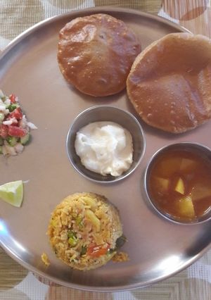 A picture of Puri, batata rassa, Masalebhat, shrikhand & Koshimbir.