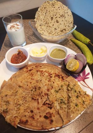 A picture of Punjabi paratha thali(radish layered paratha, Yoghurt lassi).