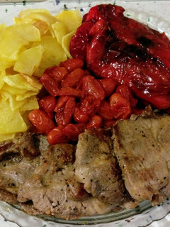 Una foto de Churrasco ibérico y tomatitos asados con patatas y pimientos fritos