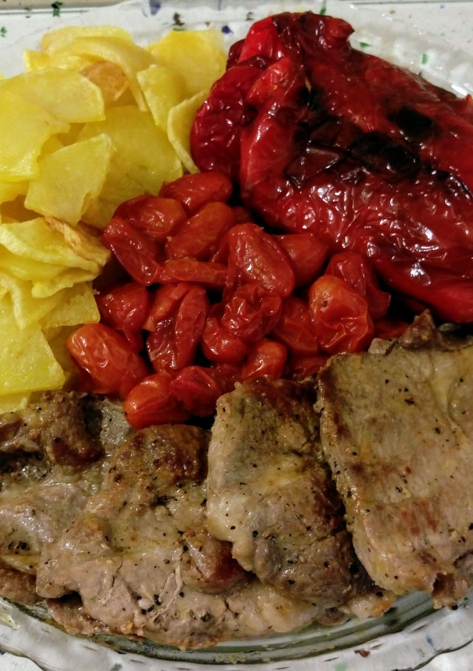 Una foto de Churrasco ibérico y tomatitos asados con patatas y pimientos fritos