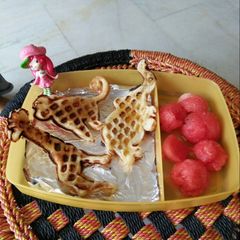 A picture of Waffles with honey syrup and watermelon.