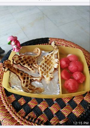 A picture of Waffles with honey syrup and watermelon.