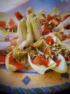 Una foto de Barquitas de endivias con salmón marinado, queso y pistachos