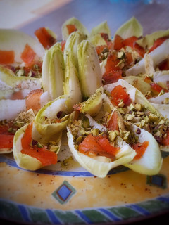 Una foto de Barquitas de endivias con salmón marinado, queso y pistachos