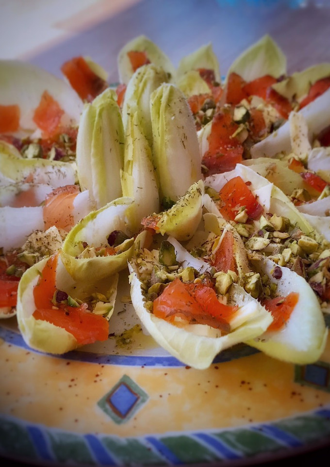 Una foto de Barquitas de endivias con salmón marinado, queso y pistachos