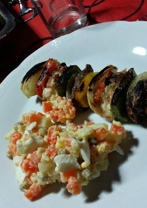 Una foto de Brochettes de carne y pollo con ensalada rusa