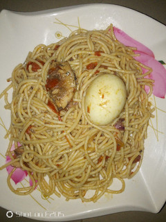 A picture of Spaghetti jollof with sardine and egg.