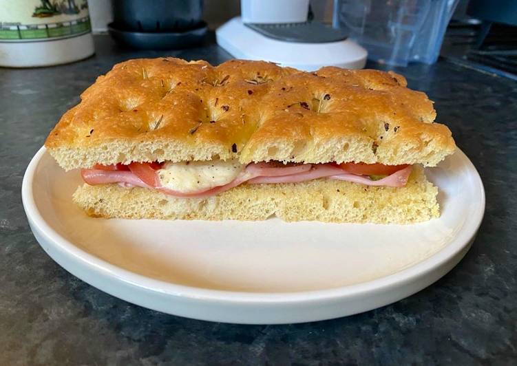 Focaccia bread with Mortadella, grilled tomatoes, melted mozzarella and cornichons Focaccia bread with Mortadella, grilled tomatoes, melted mozzarella and cornichons