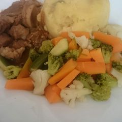 A picture of Mashed potatoes served with beef and greens.