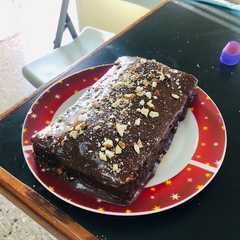 Una foto de Brownie cubierto de chocolate con almendras