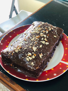 Una foto de Brownie cubierto de chocolate con almendras