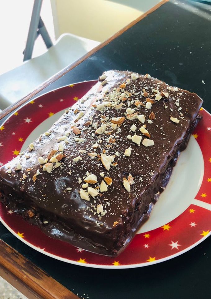 Una foto de Brownie cubierto de chocolate con almendras