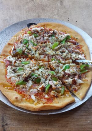 Una foto de Pizza de pollo, pimiento verde y bacon