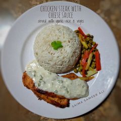 A picture of Chicken steak with cheese sauce n veggies.