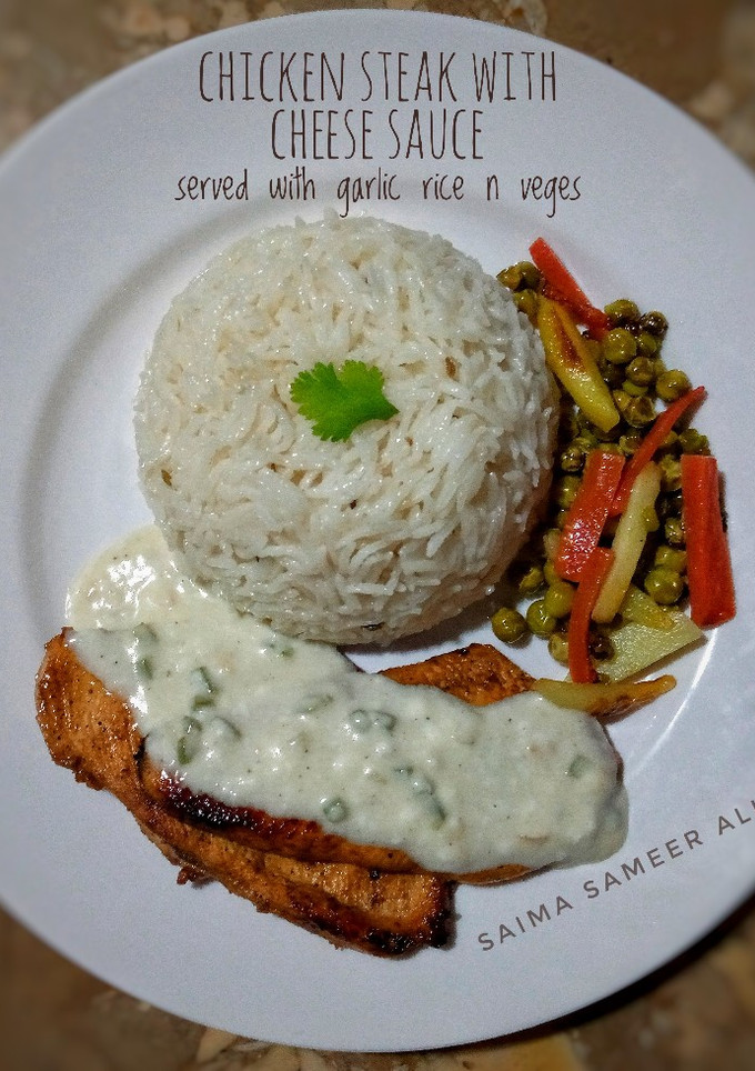 A picture of Chicken steak with cheese sauce n veggies.