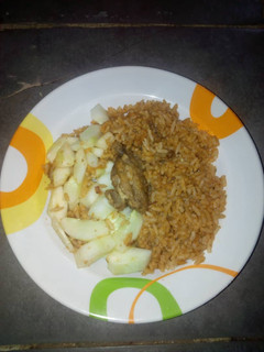 A picture of Jollof rice and cucumber.