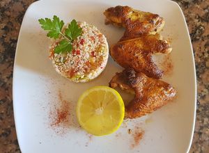 Una foto de Alitas de pollo, con couz couz, al grill, sobre brasas
